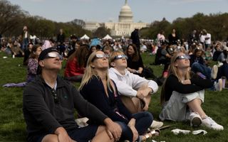 Voor het Capitool in de Amerikaanse hoofdstad Washington D.C. turen Amerikanen maandag door eclipsbrillen naar de zonsverduistering. beeld EPA, Michael Reynolds