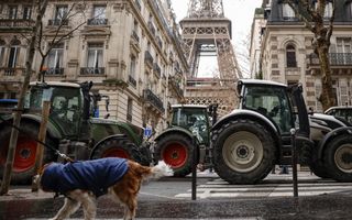 Trekkers staan in een straat. Op de achtergrond is de Eiffeltoren zichtbaar.