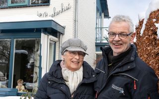 Ouder echtpaar voor wit huis waarop in gietijzeren letters ”de Boekenkist” staat.