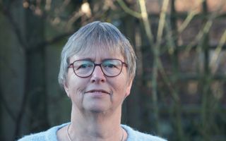 Portretfoto van een vrouw met kort, grijs haar en een bril.