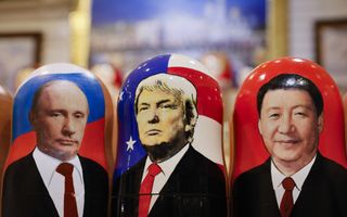 Drie Russische matroesjkapoppen op een rij, voorstellende de presidenten Xi Jinping, Poetin en Trump.