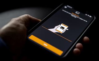 Een hand houdt een smartphone vast waarop het logo van DigiD te zien is.