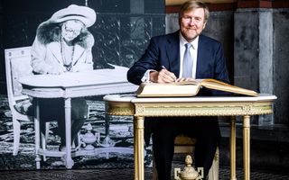 Koning Willem-Alexander tekent een gastenboek.