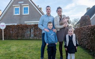 Gezinnetje met drie kinderen voor een huis met de naam Maranatha.