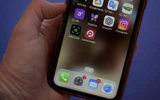 Beeld van een iPhone in een hand.