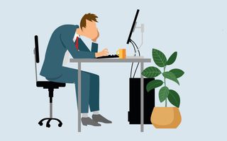 een man zit op een bureaustoel naar z’n computerscherm te kijken. Hij zit voorovergebogen.