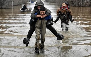 Reddingswerkers evacueren uit het overstroomde deel van de stad Orsk, in het zuidoosten van Rusland. Een groot deel van de stad is overstroomd nadat hevige regenval een nabijgelegen dam deed barsten. beeld AFP, Anatoliy Zhdanov