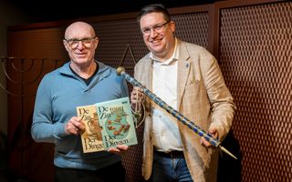 Twee mannen laten twee boeken en twee voorwerpen zien.