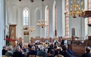 Deelnemers aan de preektocht luisteren naar college 2, door prof. dr. M.A. van Willigen, in de Grote of Sint-Martinuskerk in Dokkum. beeld Bastiaan van Soest