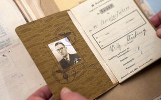 Persoonsbewijs met pasfoto en bruinige kaft.