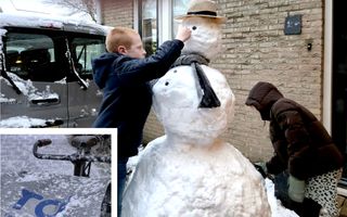 Twee kinderen maken een sneeuwpop.