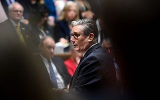 Een man met grijs haar en gekleed in een donker pak.