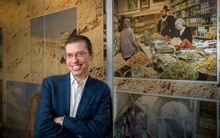 Portretfoto van een man met een bril en een keppel. 