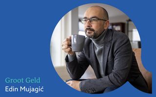 Rechthoekig blauw vlak met de tekst ”Groot Geld Edin Mujagic”. Daarnaast een foto van een man met bril en grijs jasje die een grijze mok vasthoudt.
