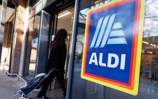 Winkel van Aldi, waarop een raam in witte letters de naam van het bedrijf staat, tegen een blauwe achtergrond.