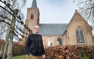 Man op leeftijd voor een oud kerkje.
