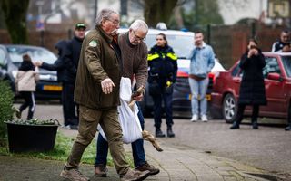 Mannen dragen witte doek waarin wolf in is gewikkeld.