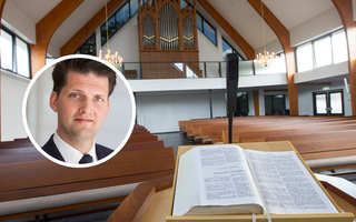 Traditioneel kerkgebouw, met achterin een pijporgel en voorin een lessenaar met daarop een kanselbijbel.