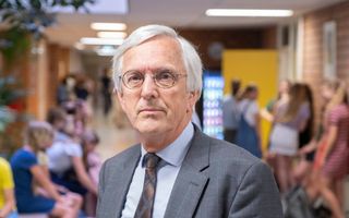 Man met grijs haar te midden van jongeren.