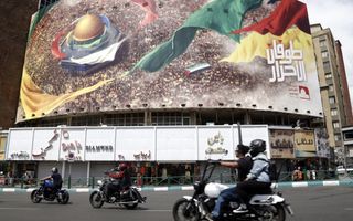 Iraniërs passeren vrijdag in Teheran een bord met anti-Israëlische tekst en beeld. beeld EPA, Abedin Taherkenareh