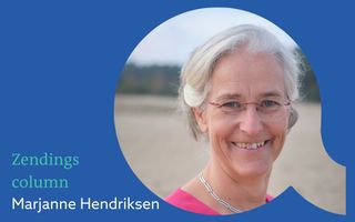 Vrouw met grijs, opgestoken haar, blauwe ogen, glimlach, zilveren halsketting om