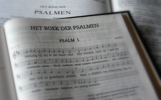 Een psalmboekje ligt op een Bijbel die openligt bij het boek der Psalmen.