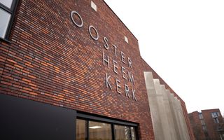 Gloednieuw kerkgebouw, met op de stenen muur de naam, Oosterheemkerk. Eronder ramen.