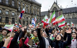 Een menigte mensen danst en zwaait met vlaggen.