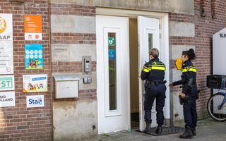 Politieagenten stappen het kinderdagverblijf in Amsterdam binnen. 
