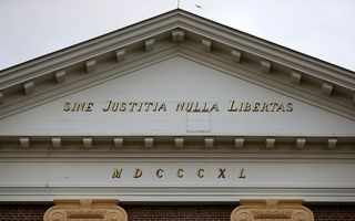 Een foto van het gevelopschrift van de rechtbank in Assen. Er staat in gouden letters: Sine Justitia Nulla Libertas (zonder gerechtigheid geen vrijheid). Daaronder het jaartal: M D C C C X L.
