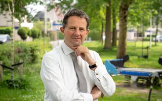 Dr. C.P. de Boer in overhemd met das, op de achtergrond een grasveld met bomen.
