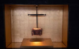 Een kruis van ongeveer 60 bij 40 centimeter, in een vitrine. 