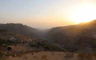 De zon gaat op over een bergachtig woestijnland.