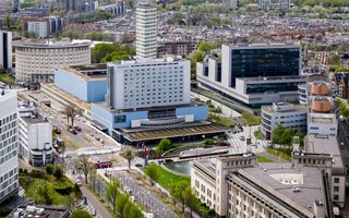 Luchtfoto van een grote stad, met op de voorgrond moderne gebouwen en een brede weg.