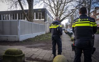 Politiemensen bij een streng beveiligd gebouw.