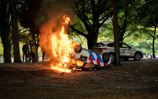 Een brandende politiewagen. 