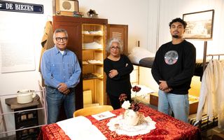 Twee mannen en een vrouw voor een kast en een stapelbed.