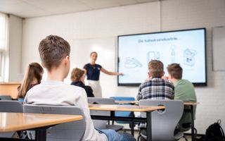 Leerlingen in een klas luisteren naar een gastdocent.