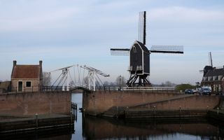 Haven met ophaalbrug en tolhuisje. Op het havenhoofd staan twee molens.