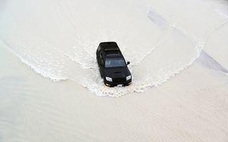Een autobestuurder rijdt door grote plassen in Dubai. De staat werd getroffen door hevige regenbuien en onweer. beeld EPA, Ali Haider