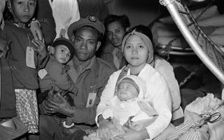 Zwart-witfoto van een militair in uniform met zijn vrouw en twee kleine kinderen.