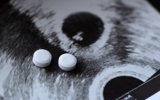 Twee witte pilletjes op de foto van een echo. 