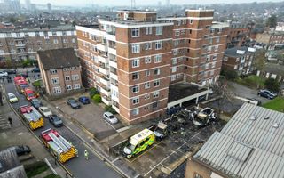Luchtfoto met daarop vier verbrande ambulances te zien voor een flatgebouw.