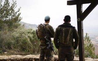 Twee soldaten, op hun rug gezien, staan op een wachtpost.