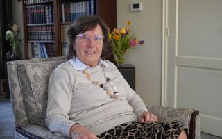 Vrouw zit in een stoel in de woonkamer