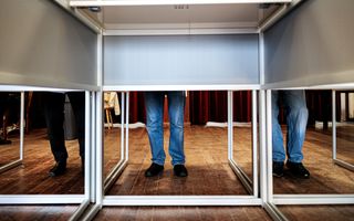 Mensen staan in een stemhokje