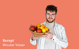 Oranje vignet met daarop een foto van een jongeman met bruin krullend haar en een baardje. Hij draagt een shirt met daarover een gestreepte blouse en heeft een schaal met fruit in zijn hand.