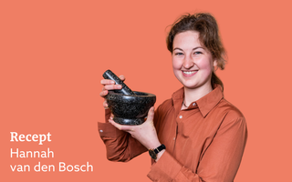 Oranje vignet met daarop een foto van een lachende jonge vrouw met een paardenstaart. Ze draagt een bruinoranje bloes en heeft een zwart schaaltje met een lepel erin in haar hand.