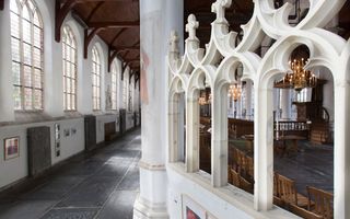 Oud kerkinterieur met hoge ramen.