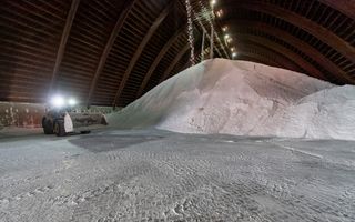 Shovel rijdt voor een zoutberg in een zoutopslag.